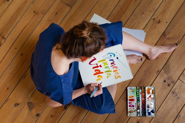 Grafikdesignerin zeichnet in bunten Farben mit Handlettering