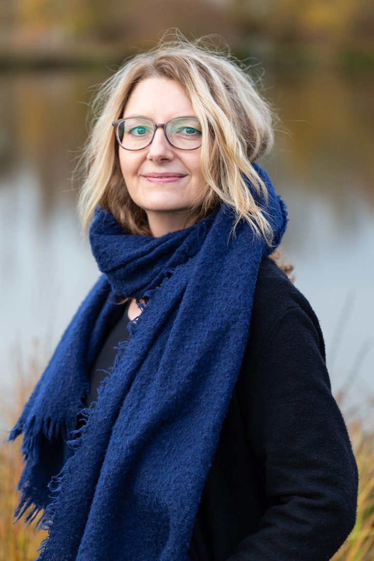 Businessportrait Mentorin Caroline an einem See, Willensstark und selbstbewusst