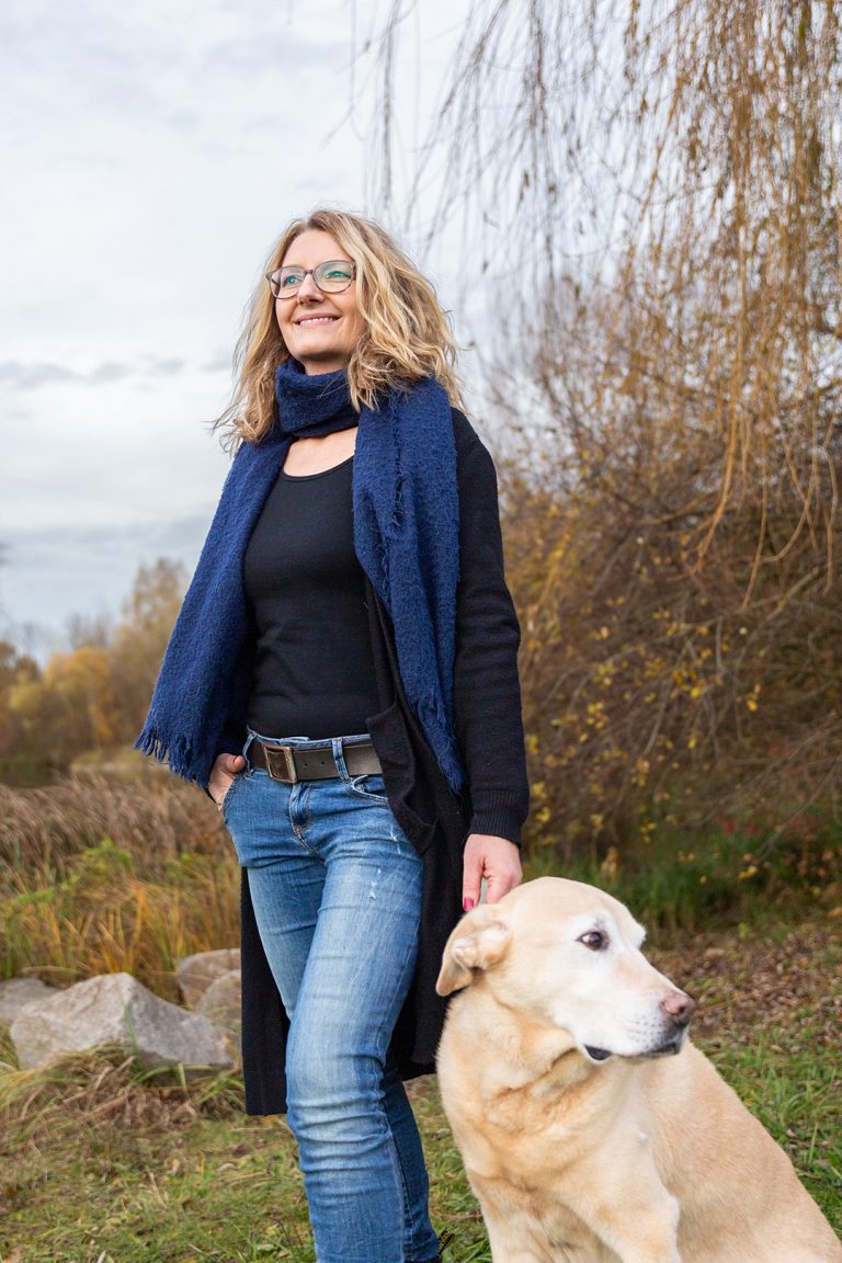Mentorin Caroline mit ihrem Hund im Wald mit Blick in die Zukunft