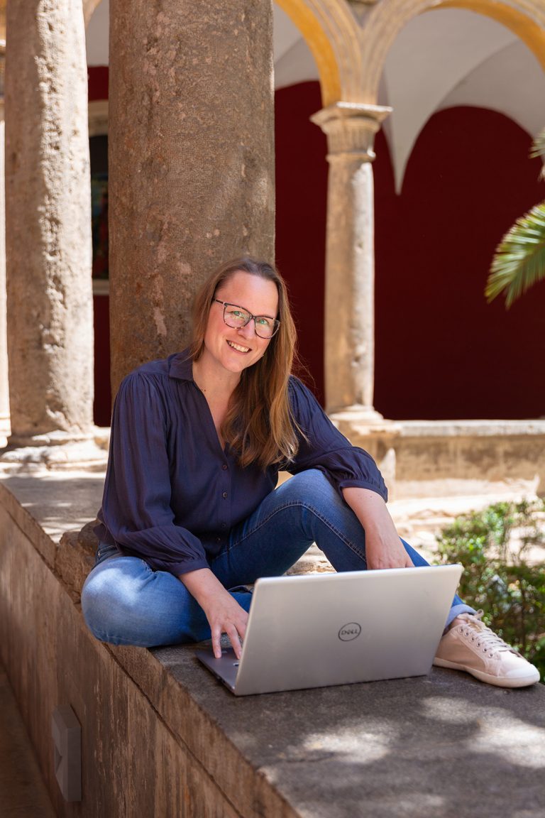 Die Deutschlehrerin bereitet ihren Unterricht am Laptop mit viel Freude und in schöner Stimmung vor