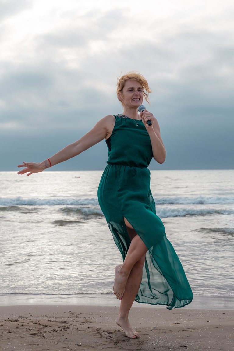 Sängerin singt und tanzt emotional am Meer
