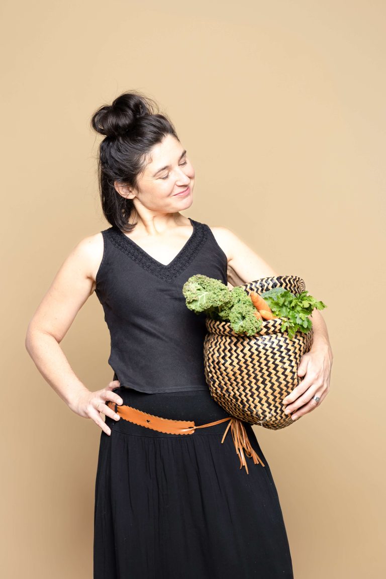 Ayurveda Beraterin freut sich über einen Korb voll Gemüse