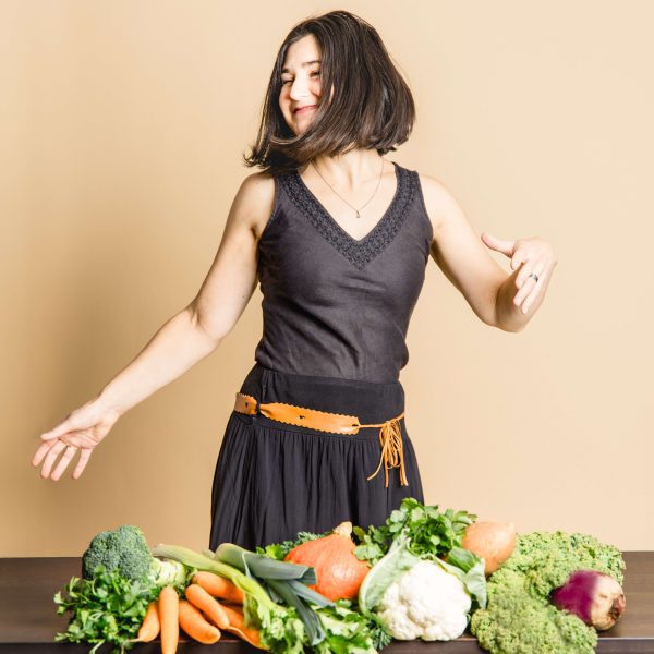 Ayurveda Beraterin tanzt weil sie glücklich ist über ihren Beruf, dass sie andere auch glücklich und gesund machen kann mit viel leckerem Gemüse