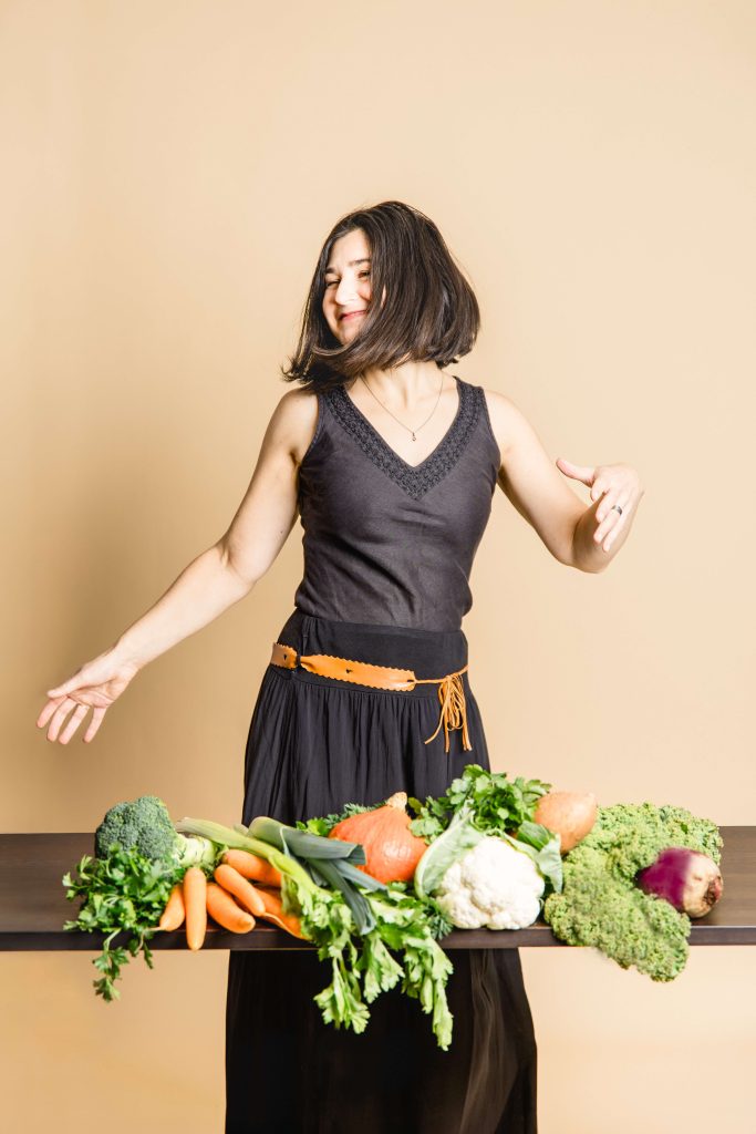 Ayurveda Beraterin tanzt weil sie glücklich ist über ihren Beruf, dass sie andere auch glücklich und gesund machen kann mit viel leckerem Gemüse