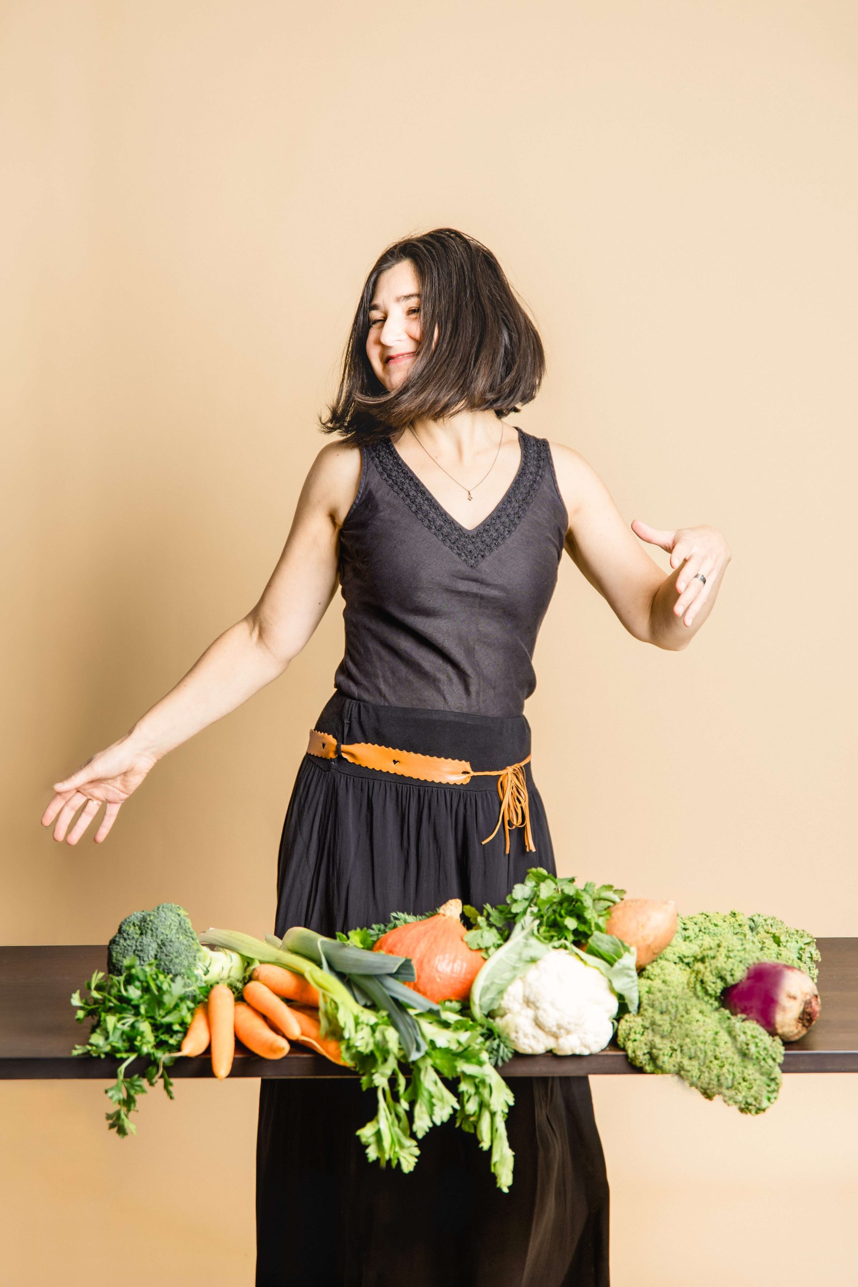 Ayurveda Beraterin tanzt weil sie glücklich ist über ihren Beruf, dass sie andere auch glücklich und gesund machen kann mit viel leckerem Gemüse
